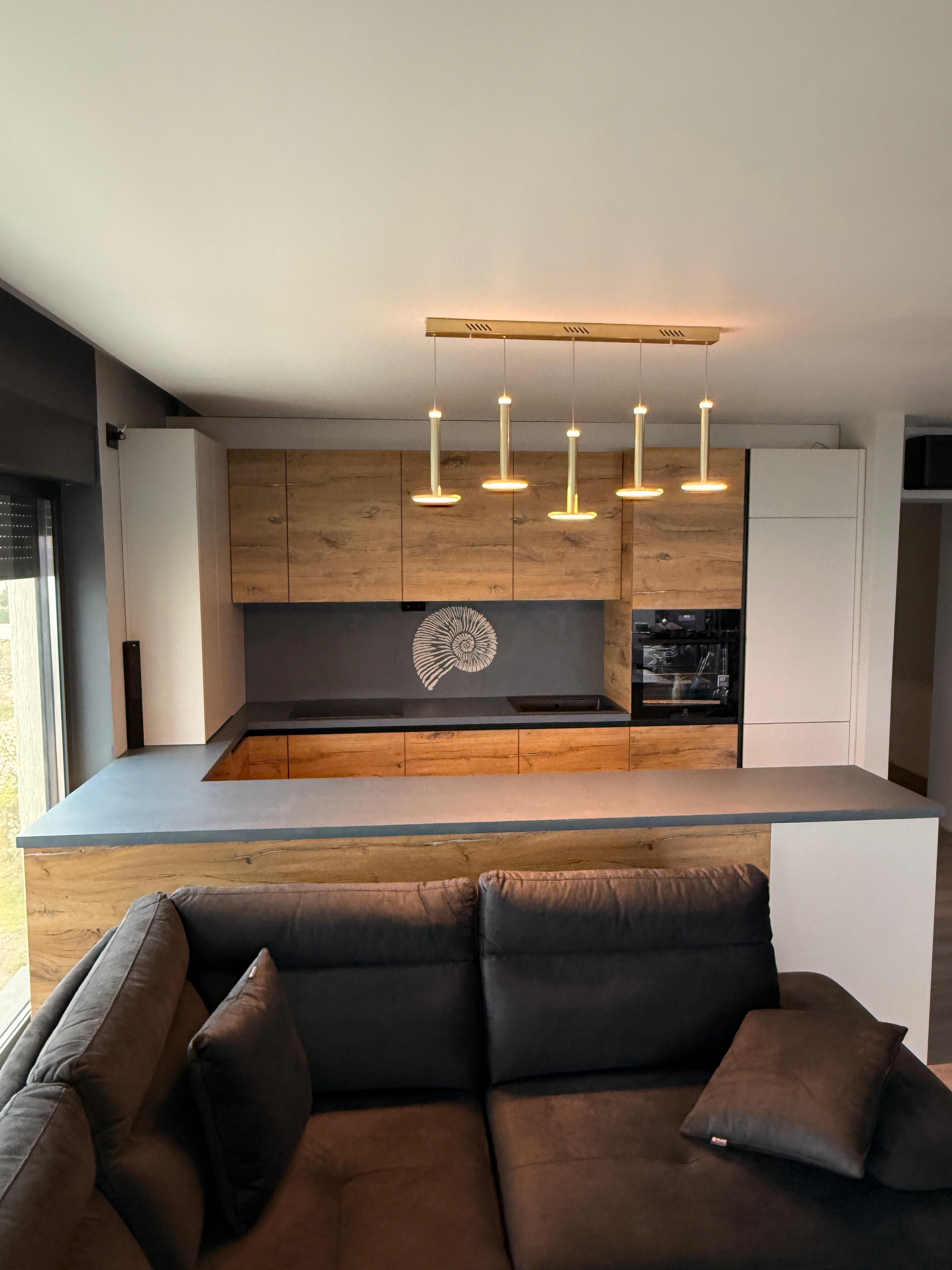 Perete accent din microcement cu motiv spiral de amonit realizat manual în tonuri calde, pământii